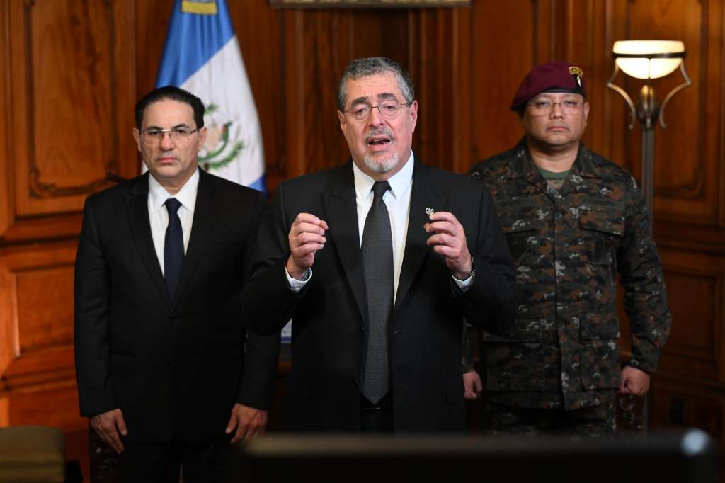 AME6633. CIUDAD DE GUATEMALA (GUATEMALA), 18/01/2026.- Fotografía cedida por la Presidencia de Guatemala de su mandatario, Bernardo Arévalo de León (c), ofreciendo un discurso junto al ministro del Interior, Marco Villeda (i), y el ministro de Defensa, Henry Saenz, este domingo, en Ciudad de Guatemala (Guatemala). Arévalo de León decretó el estado de sitio durante 30 días en todo el país después de una oleada de violencia por parte de las pandillas con ataques a las fuerzas de seguridad y motines en las cárceles. EFE/ Presidencia de Guatemala /SOLO USO EDITORIAL/NO VENTAS/ SOLO DISPONIBLE PARA ILUSTRAR LA NOTICIA QUE ACOMPAÑA (CRÉDITO OBLIGATORIO)