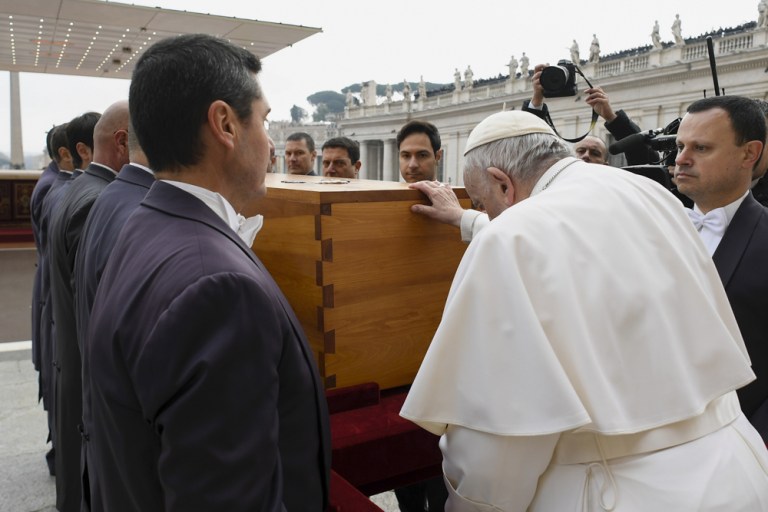 El papa Francisco, tras caminar con dificultad, bendice el ataúd del papa emérito, Benedicto XVI.