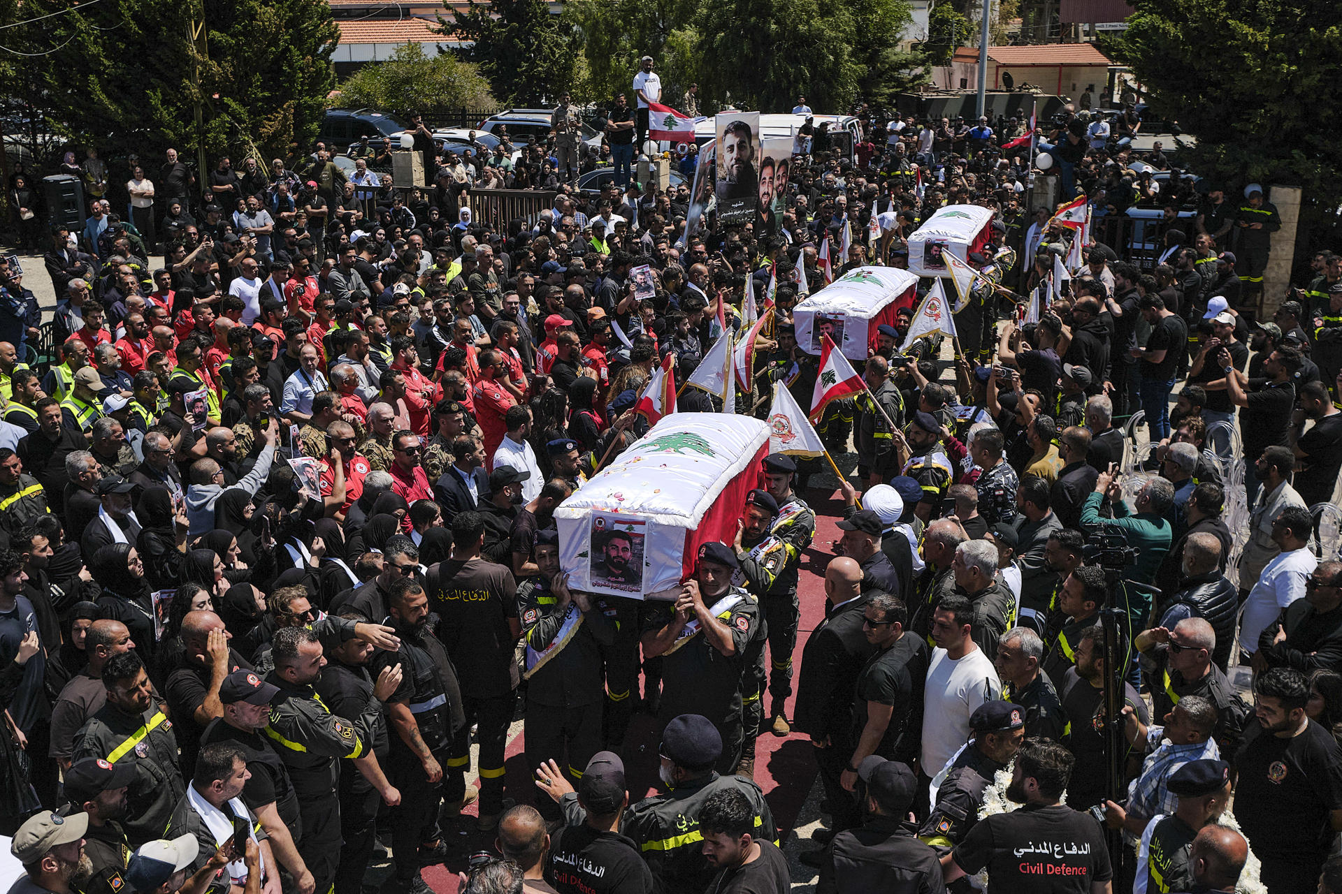 TIRO (LÍBANO), 30/04/2026.- Funeral por las tres víctimas de la Defensa Civil Libanesa muertos el martes en un bombardeo israelí en la localidad de Majdal Zoun, sur de Líbano, donde murieron un total de nueve personas y 17 heridos. Bajo la sombra de un alto el fuego violado a diario, las víctimas se siguen acumulando en el Líbano, donde esta misma semana Israel cometió una de sus mayores masacres desde el inicio de la tregua: nueve muertos en la meridional Majdal Zoun, tres de ellos paramédicos de servicio. Fue el peor ataque de toda la guerra contra la Defensa Civil Libanesa, que este jueves despidió a sus tres miembros con un funeral conjunto en Tiro, en el sur del país. Familiares, compañeros y rescatistas de otras organizaciones les dieron el último adiós entre alaridos y pétalos de rosa lanzados al paso de los féretros.EFE / Edgar Gutiérrez