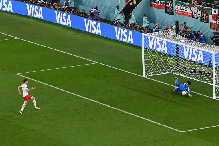 TOPSHOT - Mexico's goalkeeper #13 Guillermo Ochoa stops a penalty kick by Poland's forward #09 Robert Lewandowski during the Qatar 2022 World Cup Group C football match between Mexico and Poland at Stadium 974 in Doha on November 22, 2022. (Photo by Glyn KIRK / AFP)