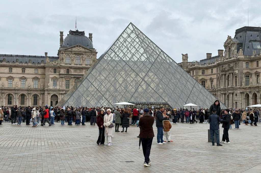 PARÍS (FRANCIA), 19/12/2025.- La plaza central del Museo del Louvre, con los turistas ante la pirámide de cristal. El Museo del Louvre de París, el más visitado del mundo con casi nueve millones de personas al año, abre este viernes todas sus instalaciones tras el anuncio de fin de huelga confirmado por sindicatos y dirección. EFE/ Pol Lloberas Cardona