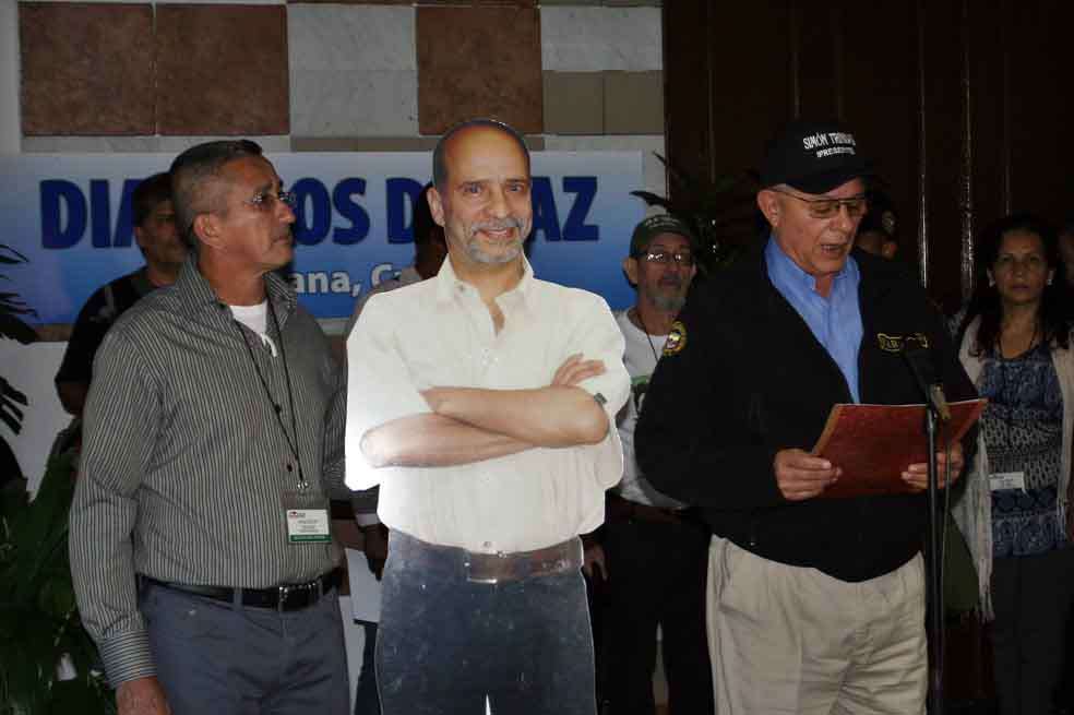 Foto tomada el 23 de noviembre de 2012 donde se ve al entonces guerrillero Rodrigo Granda (d), conocido en la guerra como Ricardo Téllez, quien lee una declaración junto a una silueta de cartón a tamaño natural de Simón Trinidad.
