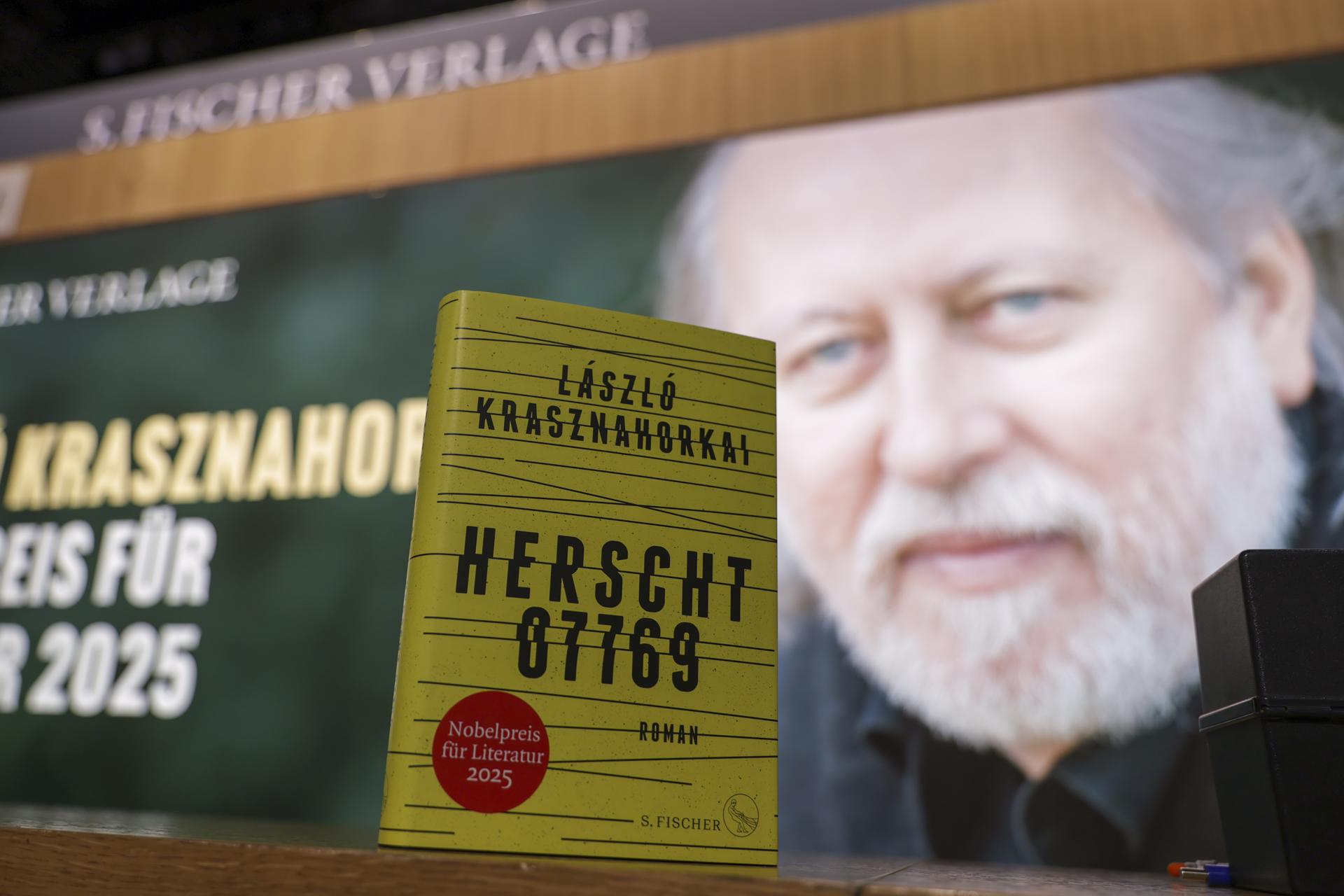 FRANKFURT (Germany), 15/10/2025.- A book and a picture of Hungarian writer Laszlo Krasznahorkai on display at a bookstand at the Frankfurt International Book Fair 2025, in Frankfurt, Germany, 15 October 2025. The 77th Frankfurt Book Fair runs from 15 to 19 October 2025. This year's Guest of Honor country are the Philippines, with the motto 'The imagination peoples the air'. (Alemania, Filipinas) EFE/EPA/CHRISTOPHER NEUNDORF