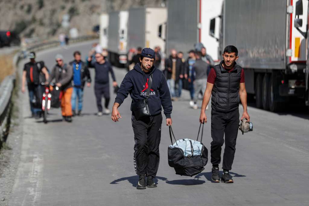 Verkhnii Lars (Georgia), 27/09/2022.- Russian men with their luggage walk along a road after passing through customs at the Georgia-Russia border checkpoint of Verkhnii Lars, Georgia, 27 September 2022. Thousands of Russian men left Russia after Russian President Putin announced in a televised address to the nation on 21 September, that he signed a decree on partial mobilization in the Russian Federation due to the conflict in Ukraine. Russian Defense Minister Shoigu said that 300,000 people would be called up for service as part of the move. Georgian Interior Minister Vakhtang Gomelauri said on 27 September, that in recent days some 10,000 Russians have crossed the border with Georgia every day. On 24 February 2022 Russian troops entered the Ukrainian territory in what the Russian president declared a 'Special Military Operation', starting an armed conflict that has provoked destruction and a humanitarian crisis. (Rusia, Ucrania, Estados Unidos) EFE/EPA/ZURAB KURTSIKIDZE
