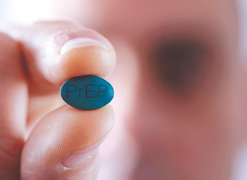 closeup of a young caucasian man with a simulated PrEP pill in his hand