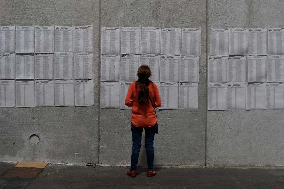 Una residente peruana revisa las listas de votantes en un colegio electoral.