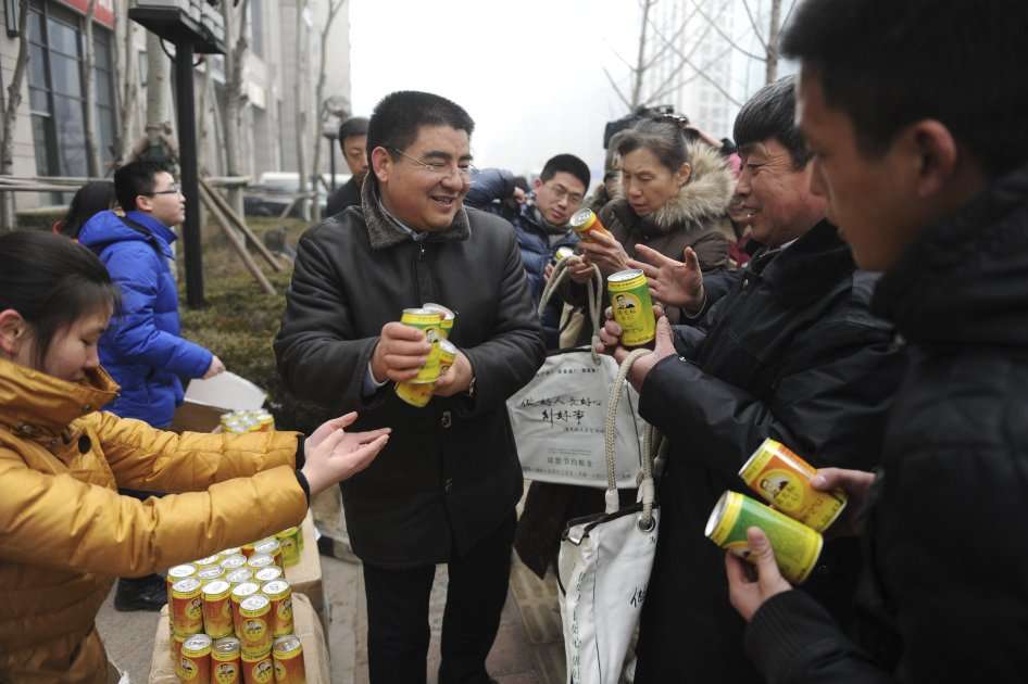 Chen Guangbiao entregando latas de aire puro. Foto: EFE