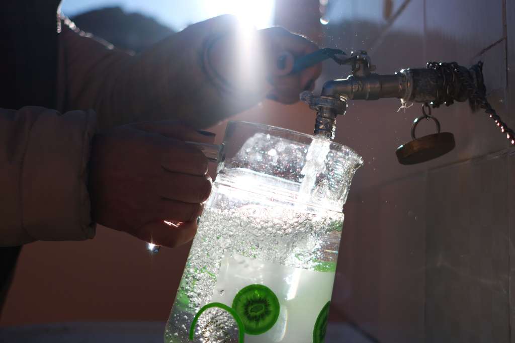 AME3021. LA PAZ (BOLIVIA), 30/05/2023.- Una mujer recibe agua en un recipiente en su domicilio, el 30 de Mayo del 2023, en La Paz (Bolivia). Tomar una ducha ya no es una situación normal en algunos barrios en La Paz, en el último mes decenas de vecinos reportaron varios síntomas como ardor en los ojos y estornudos constantes luego de ducharse, por lo que al ver que no eran casos aislados se juntaron para exigir a las autoridades bolivianas análisis sobre la calidad del agua que llega a sus hogares. EFE/Javier Mamani