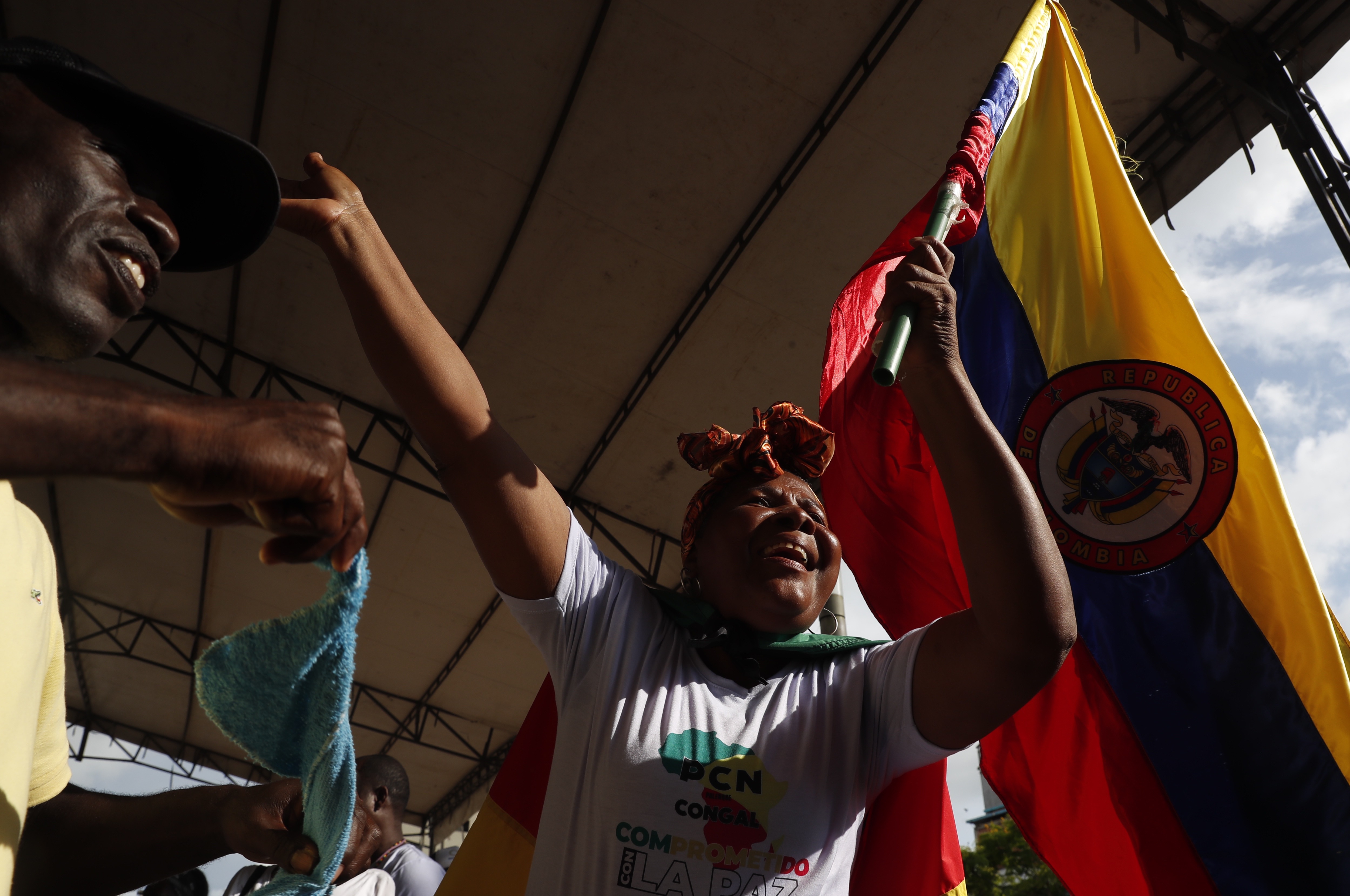 AME8659. BUENAVENTURA (COLOMBIA), 07/12/2022.- Una persona ondea una bandera de Colombia durante una reunión del diálogo social vinculante, en el marco de una tregua entre bandas que completa más de 80 días, hoy, en Buenaventura (Colombia). El presidente de Colombia, Gustavo Petro, resaltó la tregua firmada en septiembre entre los 'Shotas' y los 'Espartanos', las dos bandas más grandes de la ciudad de Buenaventura, el puerto más importante del Pacífico colombiano. El Gobierno tomó el caso de Buenaventura como ejemplo para su proyecto de "paz total". EFE/ Ernesto Guzmán