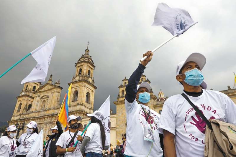 Desmovilizados de las FARC ondean banderas blancas en la Plaza de Bolívar, de Bogotá. EFE.