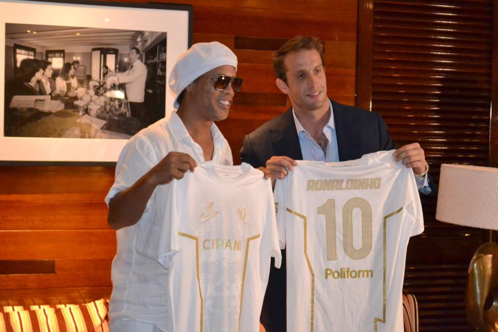 AME3858. MIAMI (ESTADOS UNIDOS), 23/06/2026.- El astro brasileño Ronaldinho Gaúcho (i) y el presidente del Ravenna, Ignazio Cipriani, posan con camisetas durante el anunció de su regreso al fútbol profesional a los 46 años de la mano del Ravenna FC italiano este martes, en Miami (Estados Unidos). "Colores nuevos, la misma sonrisa. El fútbol siempre ha sido alegría para mí y estoy emocionado de llevar ese espíritu al Ravenna. ¡Que empiece la magia!", dijo la leyenda internacional durante una presentación en el sur de Florida. EFE/ Antoni Belchi