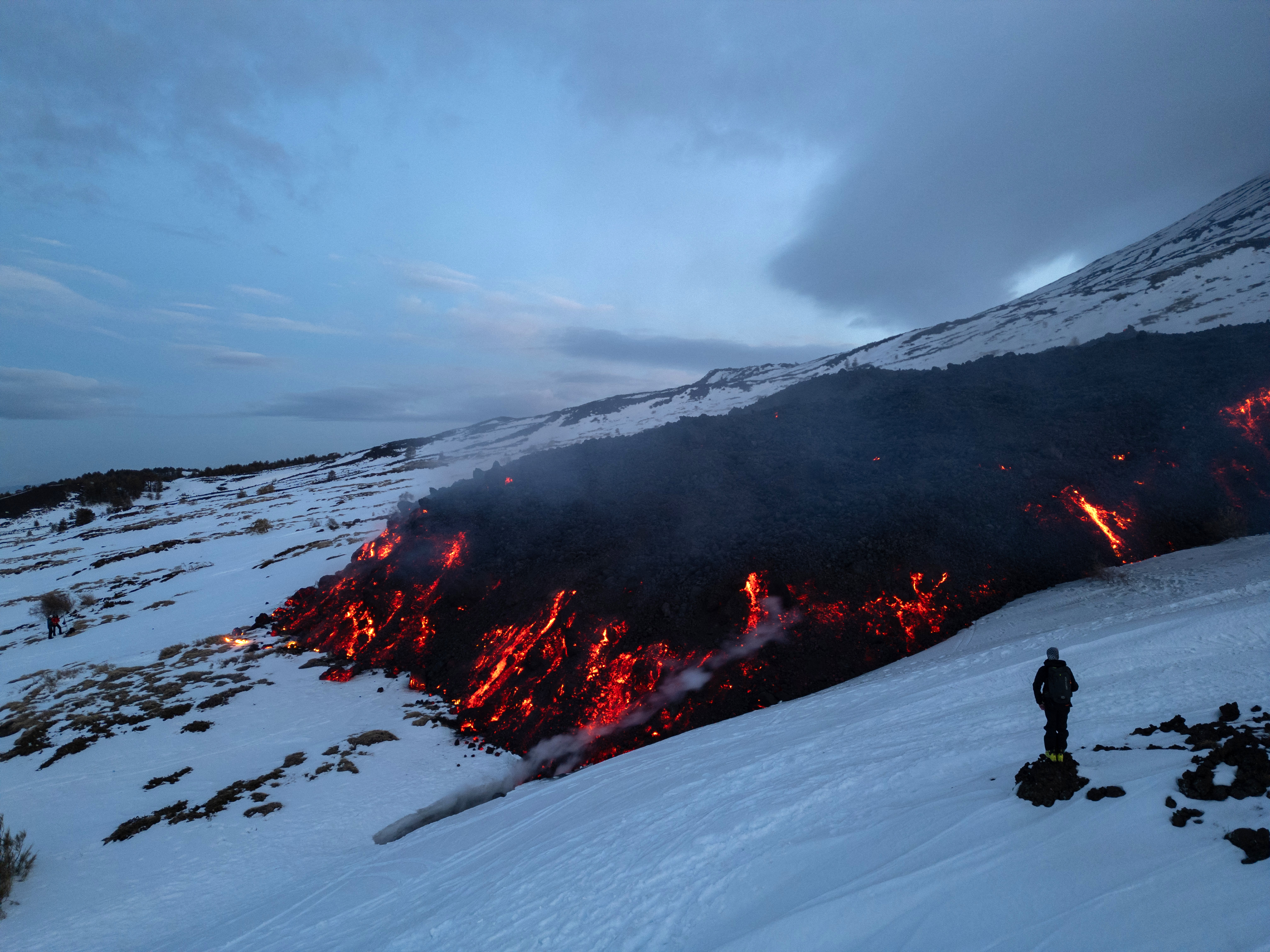 La lava rojiza del volcán más famoso de Sicilia contrasta con el blanco de la nieve en las laderas de la montaña, un paisaje irresistible para numerosos turistas y senderistas, algunos de los cuales no respetan las reglas básicas de seguridad. / Etna Walk / AFP