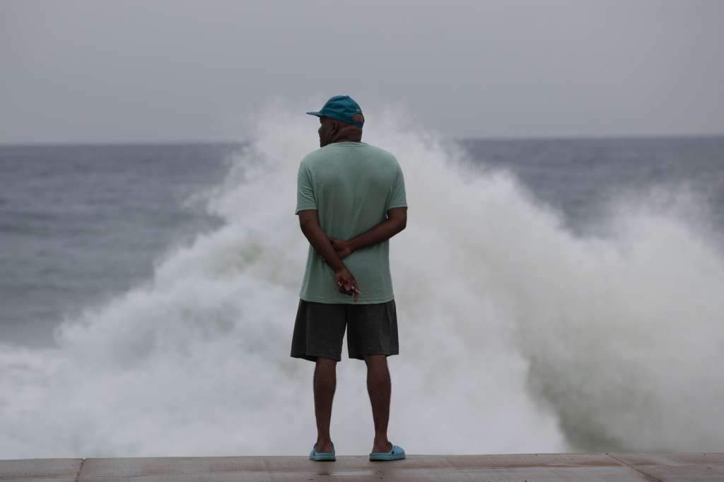 AME8771. SANTO DOMINGO (REPÚBLICA DOMINICANA), 02/07/2024.- Un hombre observa el intenso oleaje ante el avance del huracán Beryl, este martes, en Santo Domingo (República Dominicana). La República Dominicana comenzó a sentir este martes los efectos indirectos del huracán Beryl, que mantiene en alerta a los servicios de emergencia del país para atender cualquier contingencia producto del avance del fenómeno, que ya ha causado daños en varios países del Caribe. EFE/ Orlando Barría