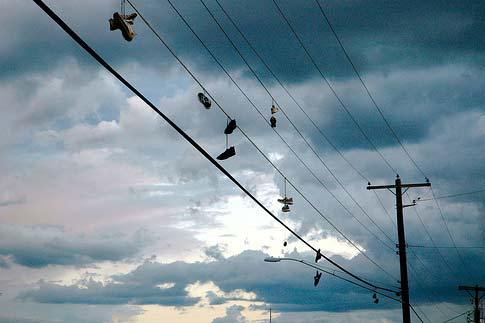 Códigos secretos detrás de zapatos colgados en cables de luz