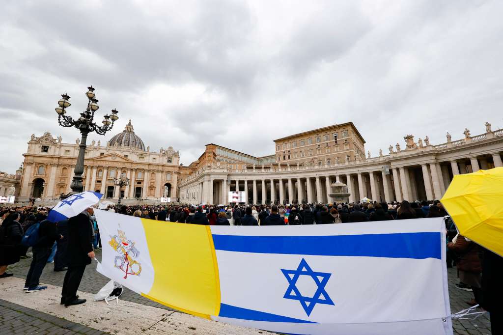 Vatican City (Italy), 19/01/2025.- People hold flags of Vatican City and Israel as Pope Francis leads the Angelus prayer, traditional Sunday's prayer, from the window of his office overlooking Saint Peter's Square, in Vatican City, 19 January 2025. (Papa) EFE/EPA/FABIO FRUSTACI