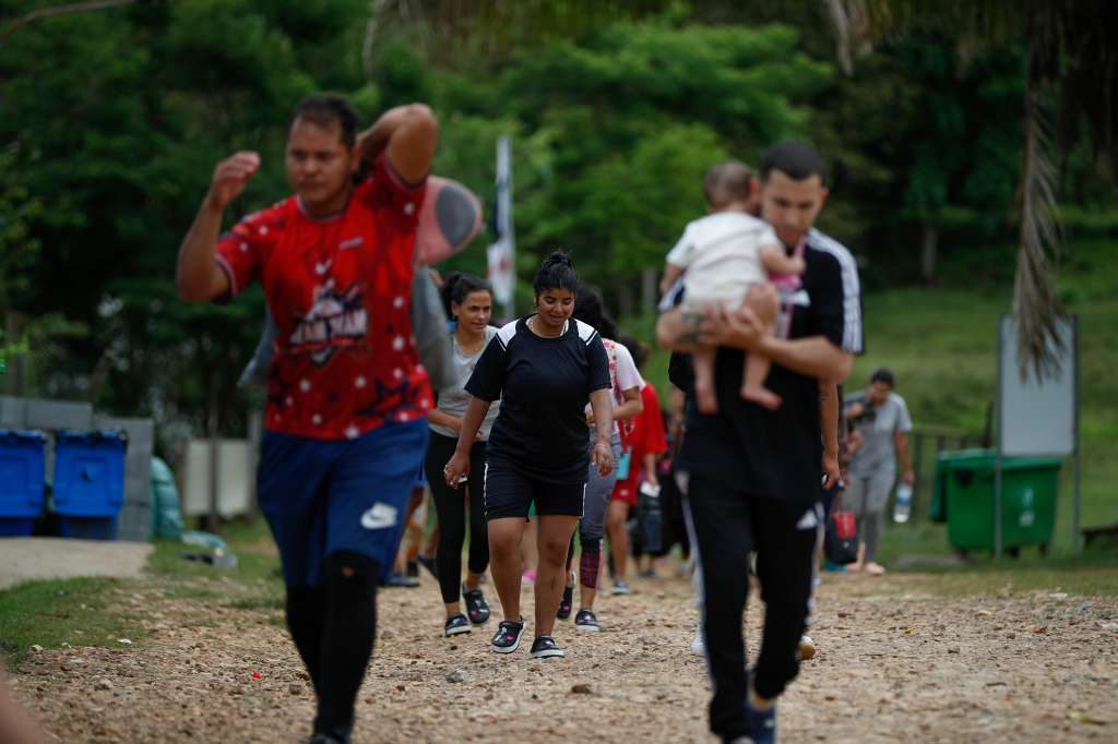 AME2835. LAJAS BLANCAS (PANAMÁ), 26/09/2024.- Migrantes caminan hacia la Estación Temporal de Recepción Migratoria (ETRM) este jueves, en Lajas Blancas en Darién (Panamá). Los venezolanos siguen siendo mayoría entre los migrantes que atraviesan la selva del Darién, la frontera natural entre Panamá y Colombia, rumbo a Norteamérica, y algunos de ellos hablan de "la peor trampa del mundo", después de que el pasado 28 de julio en las elecciones en Venezuela se proclamó, sin que se difundieran las actas, la victoria del mandatario Nicolás Maduro. EFE/ Bienvenido Velasco