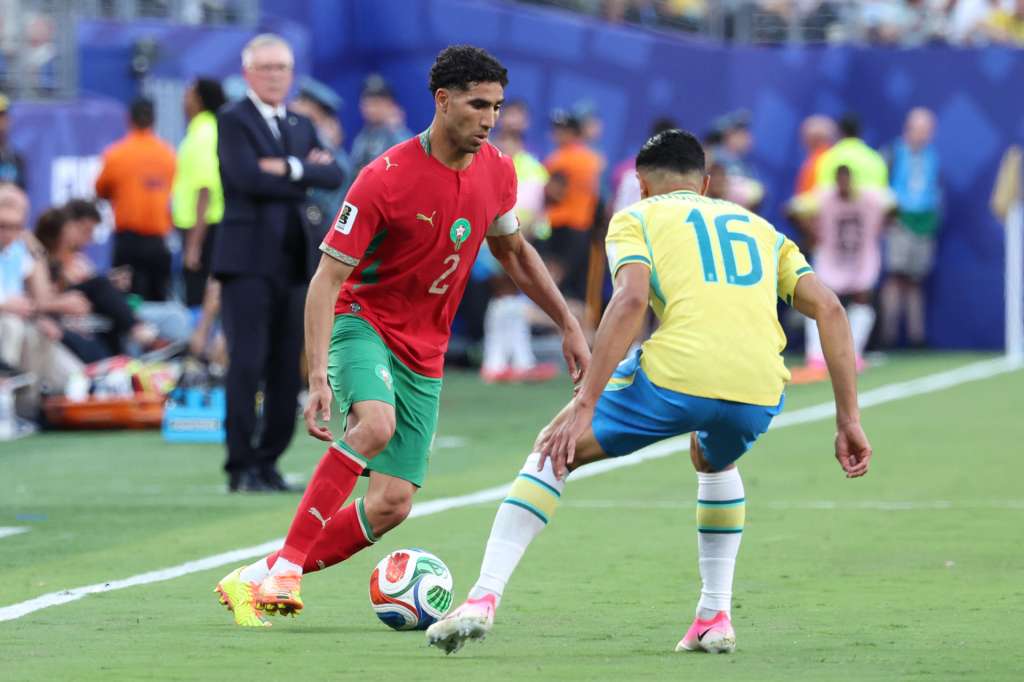 GR7147. NUEVA JERSEY (ESTADOS UNIDOS), 13/06/2026.- Douglas Santos (d) de Brasil disputa el balón con Achraf Hakimi de Marruecos este sábado, durante un partido del grupo C del Mundial de la FIFA 2026 entre Brasil y Marruecos en el estadio MetLife en Nueva Jersey (Estados Unidos). EFE/ Sebastiao Moreira