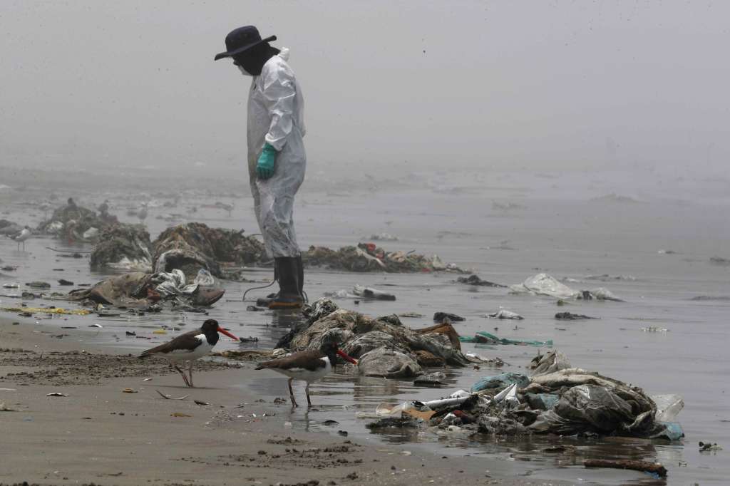 -FOTODELDIA- AME5924. LIMA (PERÚ), 15/02/2022.- Personal de limpieza limpia y recoge basura, hoy en la playa Cavero en el distrito de Ventanilla en Lima (Perú). Un mes después del desastre ambiental que sufrieron las costas de Lima tras el derrame de crudo desde la refinería La Pampilla, aún se investigan las causas del accidente, mientras que la española Repsol continúa con trabajos de limpieza que el gobierno peruano aún considera insuficientes. EFE/Paolo Aguilar