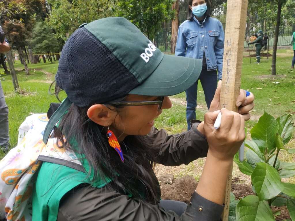 Allí está firmando la plantación que apadrinó