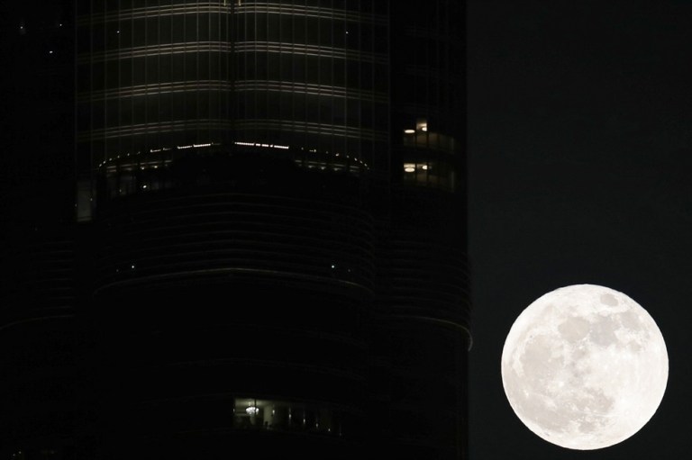 La Superluna llamada "Superluna de fresa" se eleva en el cielo detrás del edificio más alto del mundo de Burj Khalifa, en el emirato del Golfo de Dubai, Emiratos Árabes Unidos.
