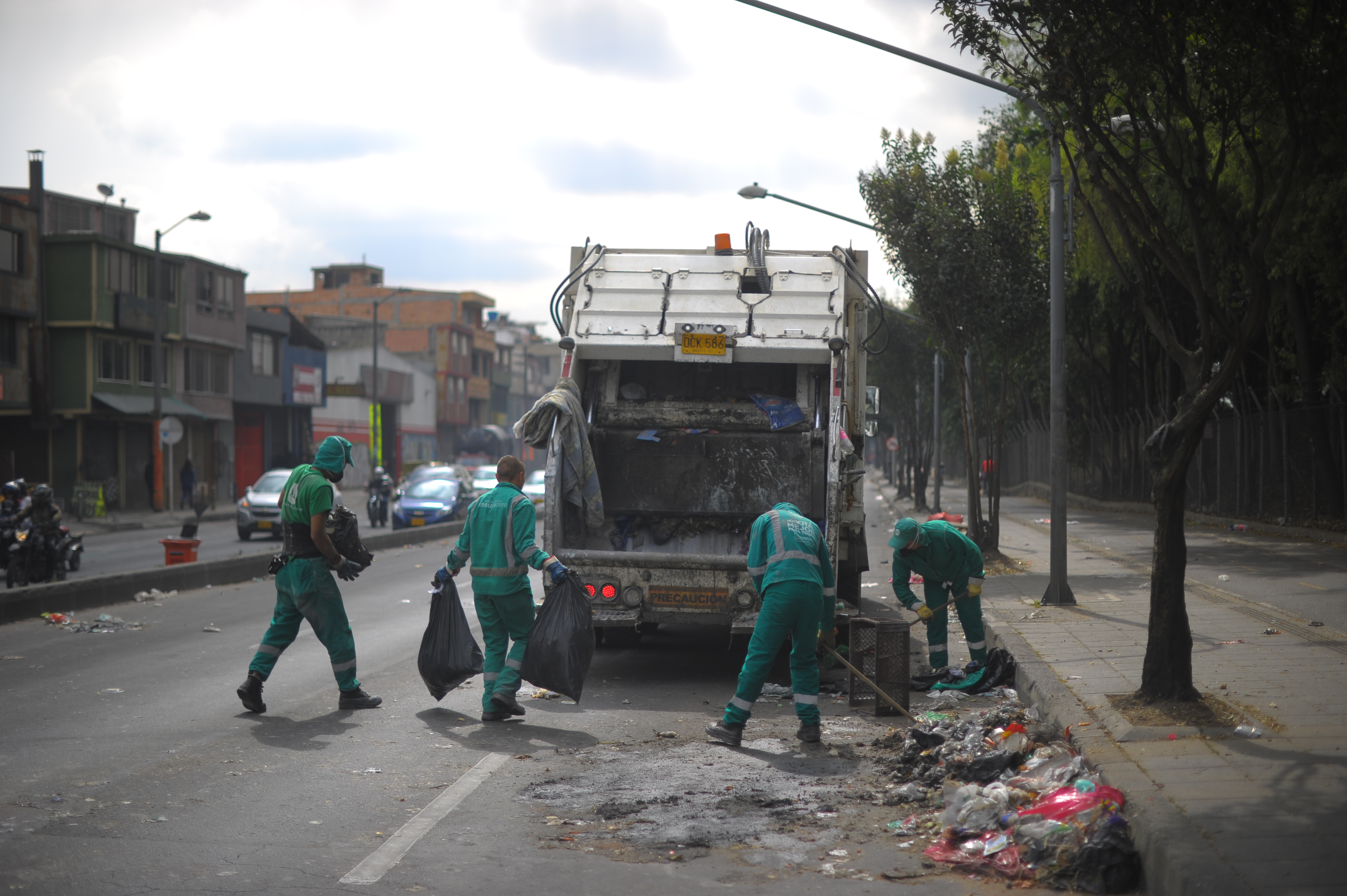 Empleados Aguas Bogotá de empresas Acueducto de Bogotá haciendo limpieza en la localidad de Engativá por emergencia sanitaria.