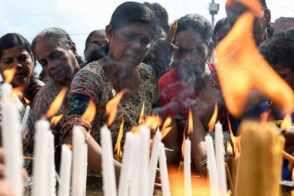Habitantes de la isla de Sri Lanka encienden velas este martes al frente de la iglesia de San Antonio, en Colombo, para conmemorar a las víctimas del atentado de Pascua. / AFP