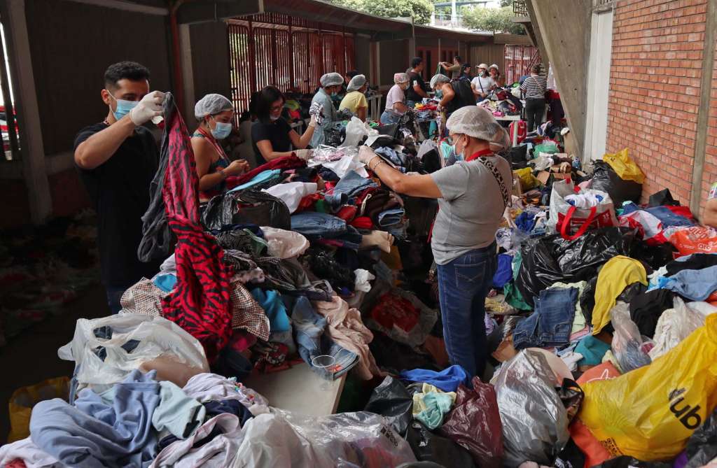 AME2824. CÚCUTA (COLOMBIA), 20/01/2025.- Personas clasifican algunas prendas que fueron donadas para los desplazados por la violencia en el Catatumbo este lunes, en el estadio General Santander en Cúcuta (Colombia). El alcalde de Cúcuta, Jorge Acevedo, aseguró este lunes que la situación por la violencia en la región de Catatumbo ya desbordó todas las capacidades de esta ciudad colombiana fronteriza con Venezuela, que se había preparado para recibir a 1.500 personas, y ya han recibido a más de 8.000. EFE/Mario Caicedo