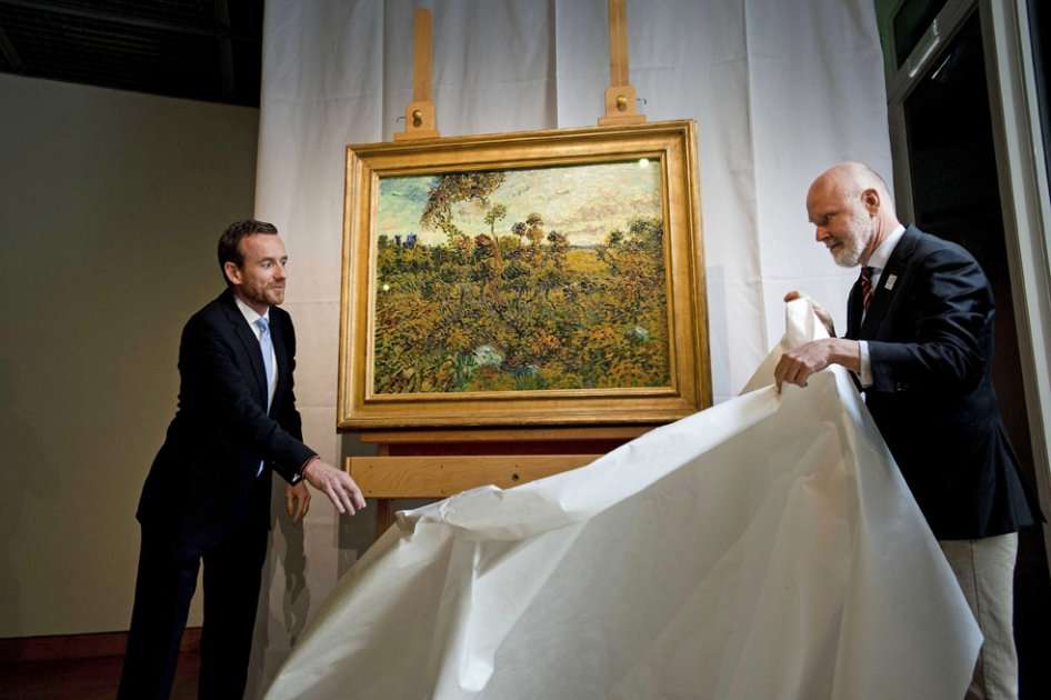 El investigador Louis van Tilborgh (dcha) y el director Alex Rüger (izq), del Museo Van Gogh, presentan la pintura de Vincent Van Gogh "Puesta de sol en Montmajour"./ EFE