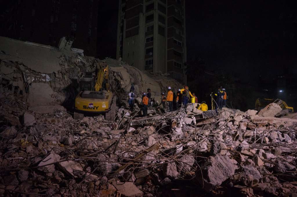 AME4652. CARACAS (VENEZUELA), 25/06/2026.- Integrantes de equipos de rescate trabajan este jueves, en un edifico afectado por un terremoto en la zona de Altamira en Caracas (Venezuela). Al menos 235 muertos y 4.300 heridos han sido reportados por las autoridades de Venezuela pasadas las 24 horas de dos terremotos, de magnitud 7,2 y 7,5, que afectaron principalmente a Caracas y al estado cercano La Guaira, mientras continúan las labores de búsqueda de supervivientes y el Gobierno sigue evaluando los daños materiales. EFE/ Boris Vergara