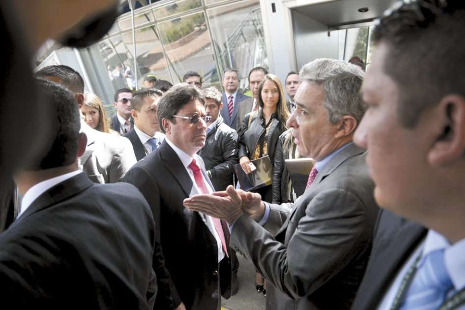 El expresidente Uribe dando directrices en la convención del Centro Democrático, con la mirada atenta de Francisco Santos.