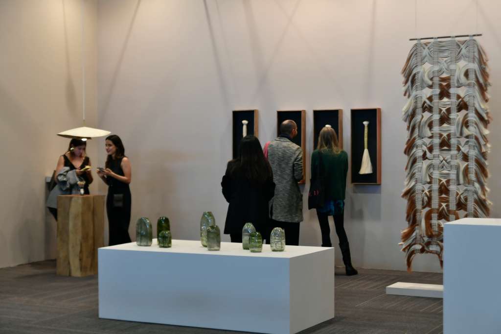 Exposición de obras de arte y asistentes a esta feria.