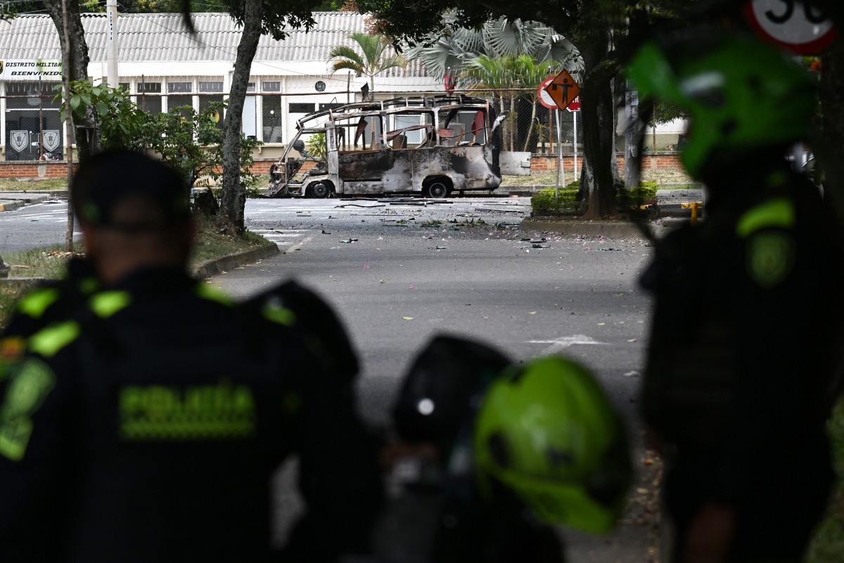 Colombian police officers stand next to a bus bomb after an explosion near a military base in Cali, Valle del Cauca department, Colombia taken on April 24, 2026.