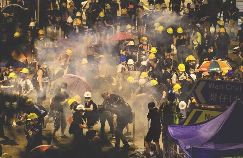 La policía de Hong Kong dispara gases lacrimógenos contra un grupo de manifestantes que había irrumpido en la sede del Parlamento el 2 de julio. / AFP