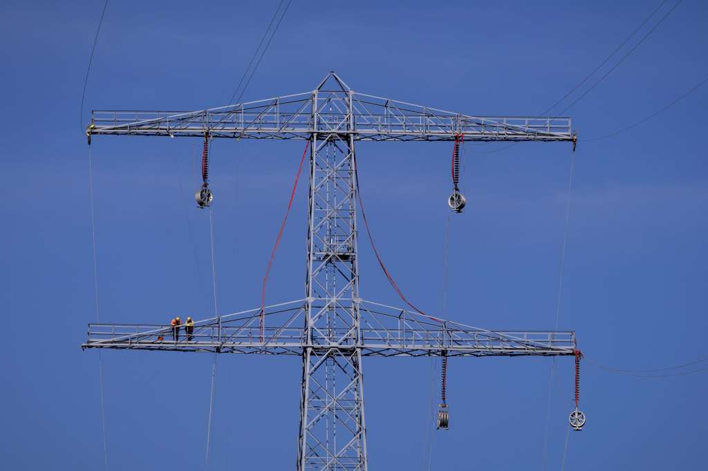 Hansweert (Netherlands), 10/08/2026.- TenneT employees remove lines from a high-voltage pylon in Hansweert, The Netherlands, 10 August 2026. In Zeeland, a number of pylons are being removed to make way for new ones. To remove the high-voltage lines, shipping traffic on the Canal van Zuid-Beveland must be halted multiple times. (Países Bajos; Holanda) EFE/EPA/ROBIN VAN LONKHUIJSEN
