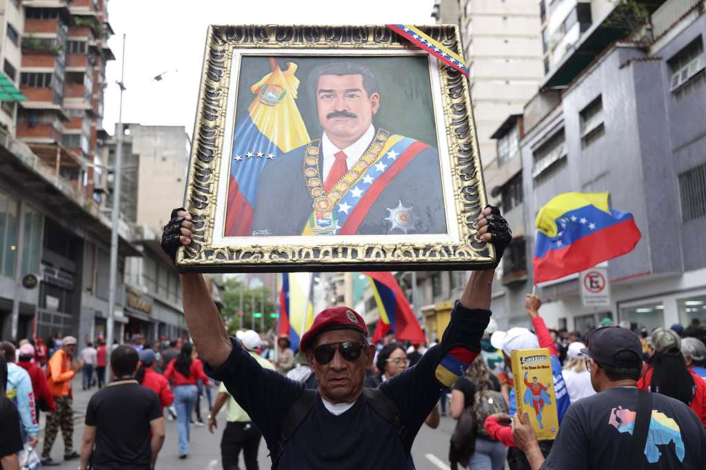 AME5213. CARACAS (VENEZUELA), 14/01/2026.- Una persona sostiene una imagen del presidente de Venezuela, Nicolás Maduro, durante una manifestación este miércoles, en Caracas (Venezuela). El chavismo volvió a movilizarse en las calles de Caracas y llamó a los venezolanos a no claudicar hasta que Estados Unidos libere a Maduro y a su esposa, Cilia Flores, quienes fueron capturados por fuerzas estadounidenses en una operación en Caracas el pasado 3 de enero. EFE/ Ronald Peña R
