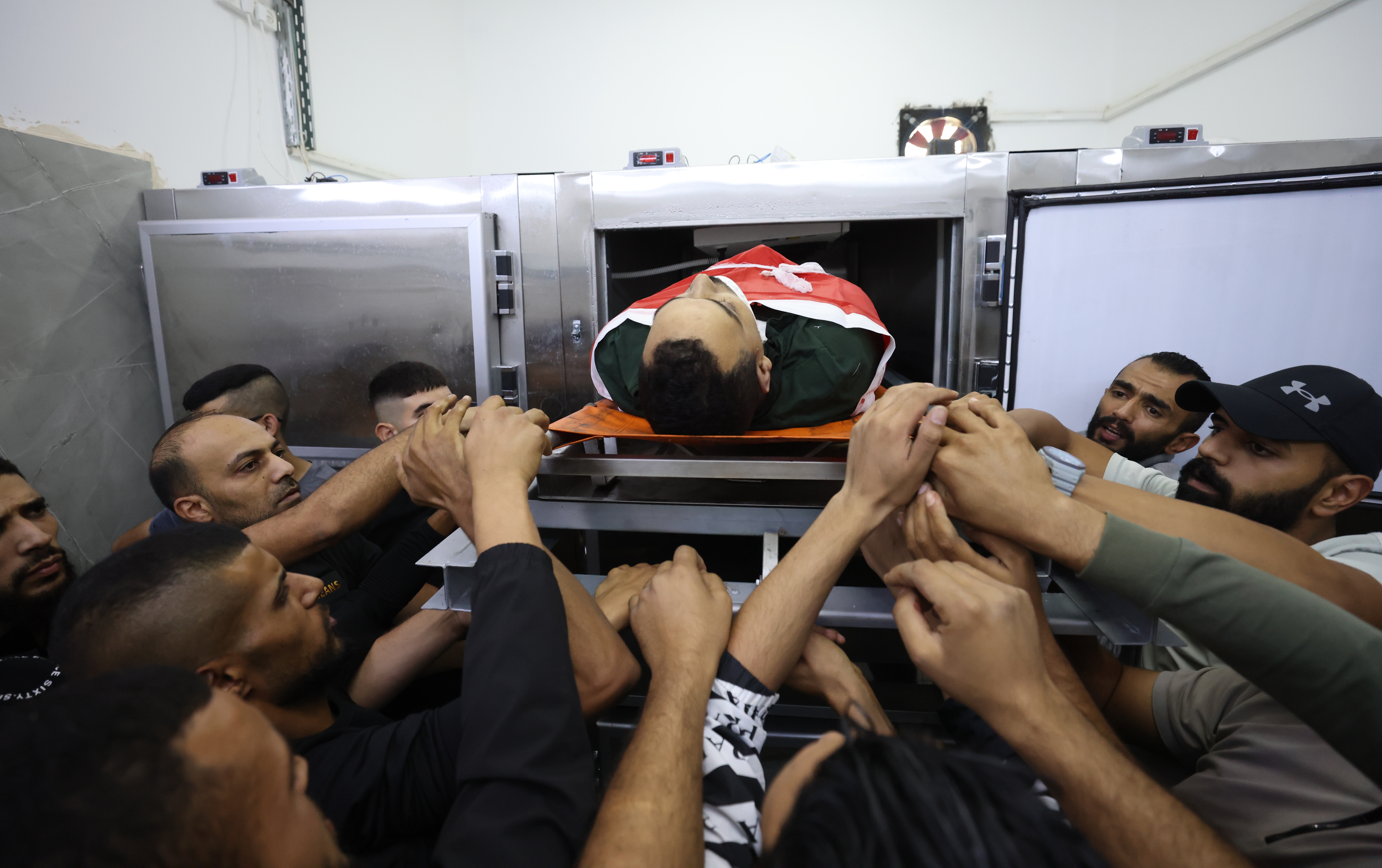 Jenin (-), 03/11/2023.- Mourners carry the body of a Palestinian man killed during an Israeli raid at Jenin refugee camp, at the hospital in the West Bank city of Jenin, 03 November 2023. According to the Palestinian Health Ministry, at least five Palestinians were killed during Israeli raids in Jenin refugee camp. More than 130 Palestinians have been killed and about 2,100 injured in the West Bank between 07 October and 02 November, following the escalation of hostilities between Israel and Hamas, the ministry said. (Yenín) EFE/EPA/ALAA BADARNEH