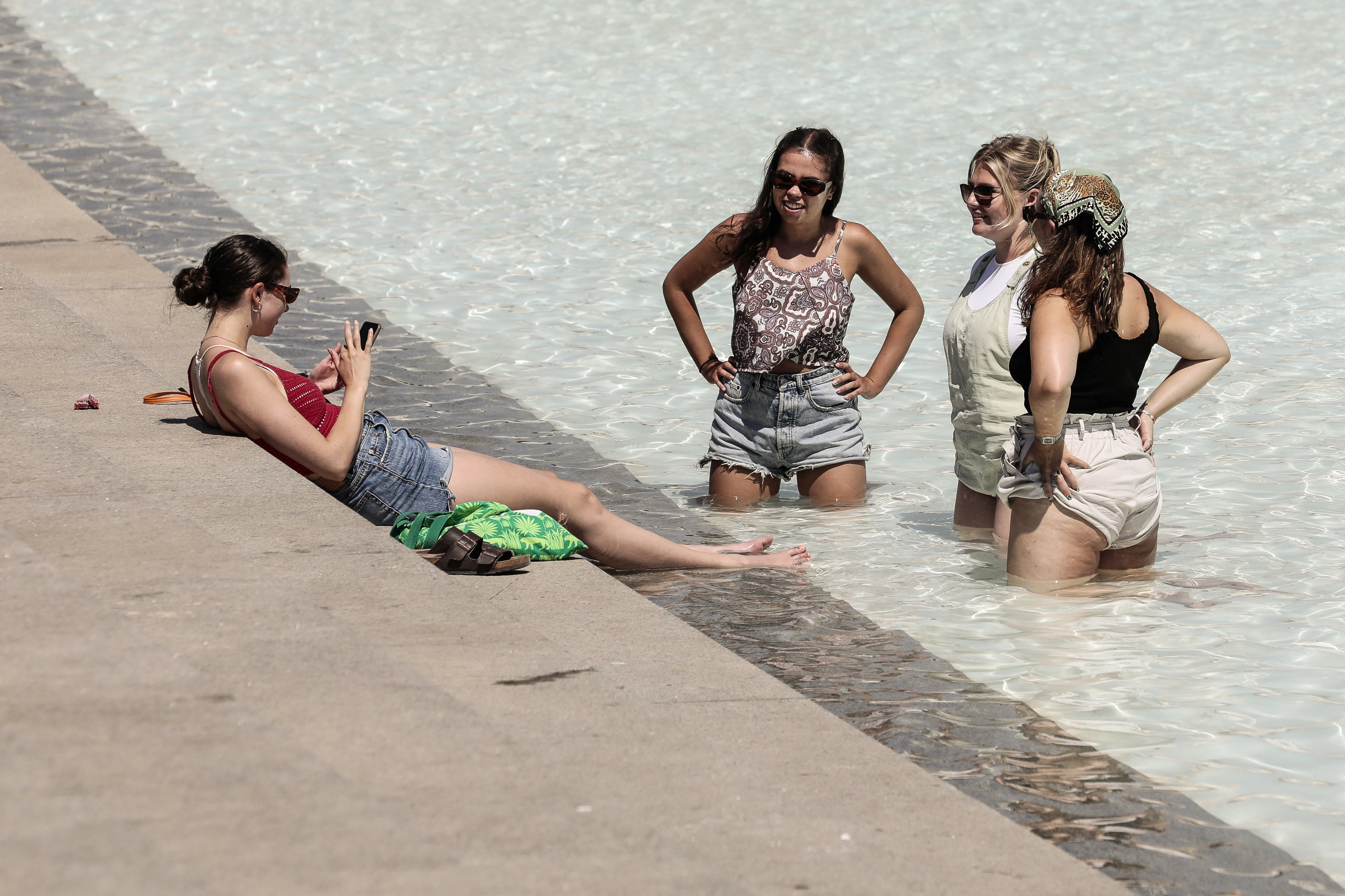 GRAFCVA7270. VALENCIA, 18/07/2022.- Unas jóvenes se refrescan en una fuente este lunes en la ciudad de Valencia. La Conselleria de Sanidad ha declarado este lunes el nivel de alerta sanitaria por ola de calor alto y extremo en municipios de 19 comarcas de la Comunitat Valenciana. EFE/Ana Escobar