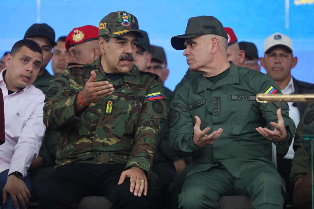 AME2673. CARACAS (VENEZUELA), 25/11/2025.- El presidente de Venezuela, Nicolás Maduro (i), habla con el ministro de Defensa Vladimir Padrino López este martes, durante una marcha en Caracas (Venezuela). Maduro expresó que el país enfrenta una "coyuntura decisiva para su existencia" como república, en la que, dijo, está "prohibido fallar" en la defensa de la nación frente a "las amenazas" de EE.UU. EFE/ Miguel Gutiérrez