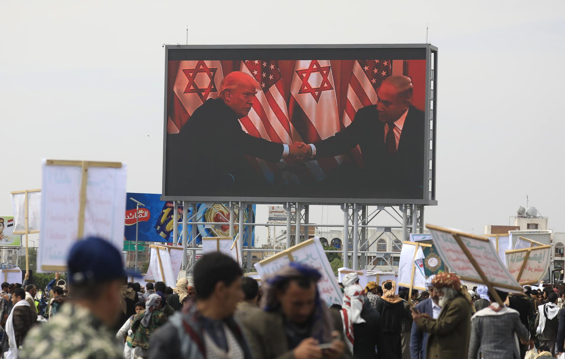 Sana'a (Yemen), 25/04/2025.- Houthi supporters gather in front of a digital billboard featuring US President Donald Trump (L) and Israeli Prime Minister Benjamin Netanyahu (R) during a protest against the United States, in Sana'a, Yemen, 25 April 2025. Thousands of Houthi supporters took to the streets of Sana'a to protest against US airstrikes targeting several Yemeni cities since mid-March. The Houthis have launched several attacks with more than 20 drones and missiles against US military vessels in the Red Sea and shot down three US Army MQ-9 Reaper drones over Yemen in the last week, Houthi leader Abdul-Malik al-Houthi said in a televised speech. (Protestas, Estados Unidos) EFE/EPA/YAHYA ARHAB
