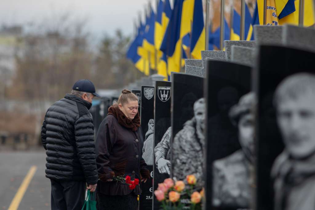 Padres de familia visitan la tumba de su hijo caído en combate en el cementerio de Cherkasy.