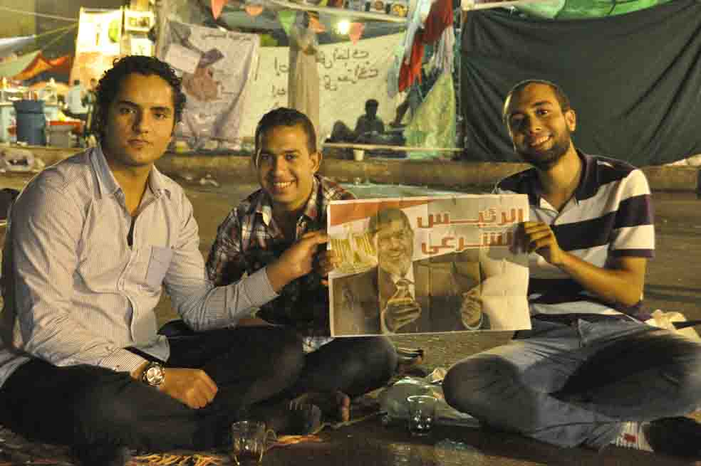 Un grupo de jóvenes sostiene una imagen del depuesto presidente, Mohamed Mursi, en las calles de El Cairo. / Víctor de Currea-Lugo