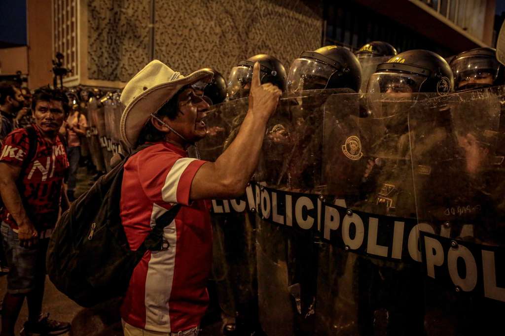 -FOTODELDÍA- AME1779. LIMA (PERÚ), 04/02/2023.- Un manifestante increpa hoy a policías antidisturbios en el centro de Lima (Perú). Una reportera y un fotoperiodista fueron agredidos por la Policía este sábado mientras cubrían una marcha antigubernamental en Lima, donde los agentes también "restringieron" la cobertura de un equipo de prensa que registraba "excesos" policiales, denunció la Asociación Nacional de Periodistas del Perú (ANP). EFE/Jhon Reyes