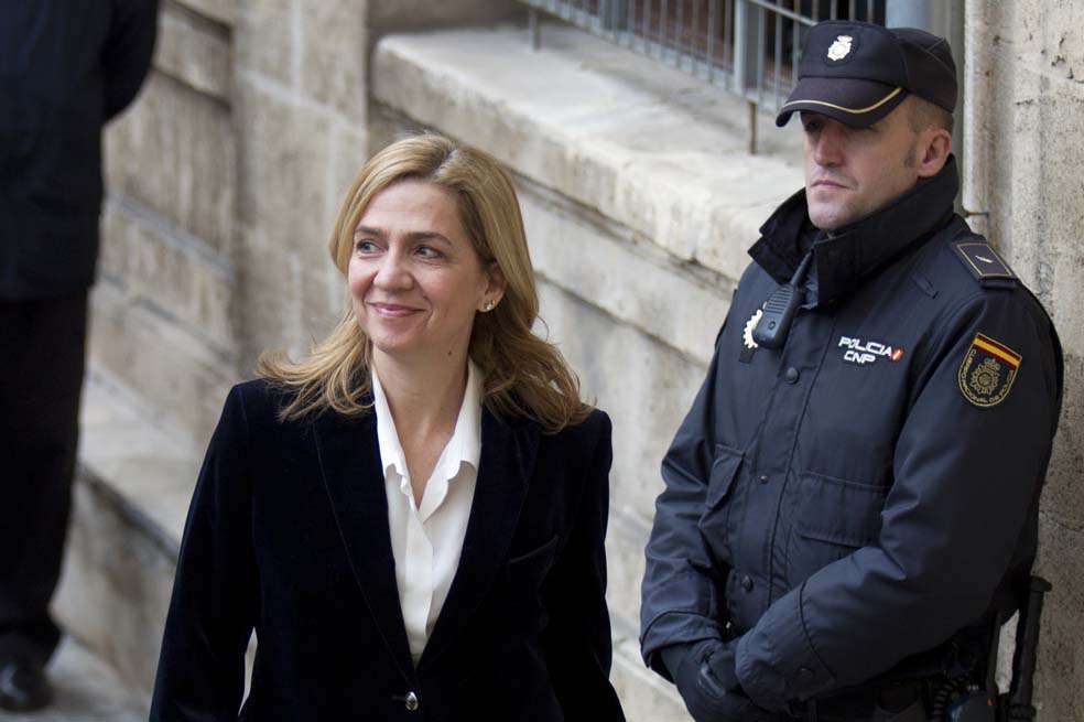 (FILES) A file picture takenon February 8, 2014 shows Spanish Infanta Cristina (L) smiling as she arrives at the courthouse of Palma de Mallorca, on the Spanish Balearic Island of Mallorca. A Spanish judge ruled on June 25 that King Felipe VI's sister, Princess Cristina, and her husband must face fraud charges, opening the way to an unprecedented criminal trial. Less than a week after Felipe, 46, took the Spanish throne promising an "honest and transparent" monarchy, the ruling refocused attention on a scandal that had blighted the reign of his 76-year-old father Juan Carlos. AFP PHOTO / JAIME REINA