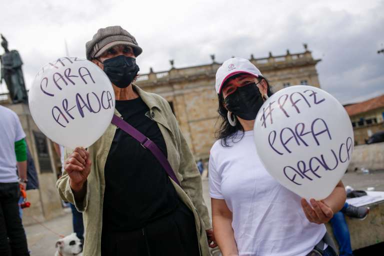 Dos mujeres sostienen bombas que dicen paz para Arauca