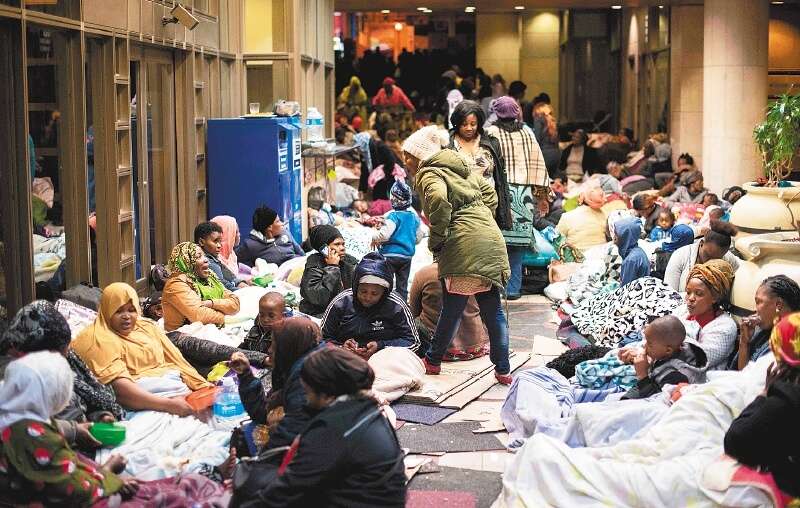 Personas acampando en un corredor cerca de las oficinas de la Alta Comisión de las Naciones Unidas para los Refugiados (ACNUR) el 9 de octubre de 2019 en Ciudad del Cabo. / AFP
