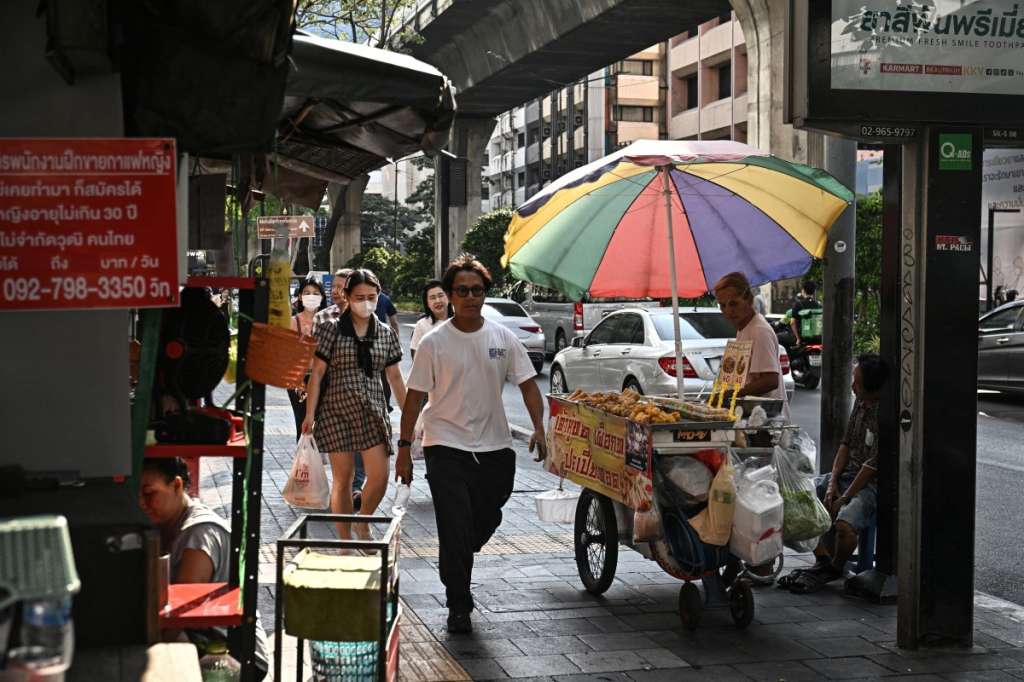 This photo taken on April 30, 2026 shows a street vendor selling fried food along Silom road in Bangkok.