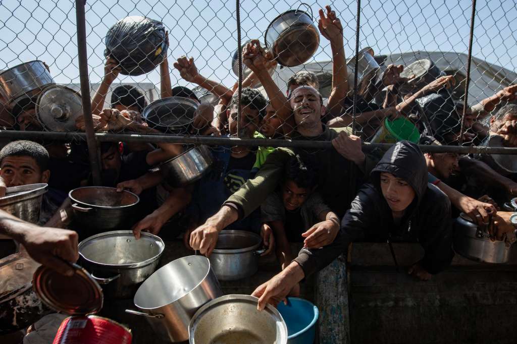 GAZA (-), 30/05/2025.- Internally displaced Palestinians gather outside a charity kitchen to receive limited rations amid a shortage of food, in Khan Younis, southern Gaza Strip, 30 May 2025. The United Nations has warned that "the entire population of Gaza is facing the risk of famine" since Israel closed border crossings on 02 March 2025, preventing the entry of essential supplies. The Gaza Government Media Office reported on 24 May that at least 58 people died due to malnutrition, and nearly 250 others due to a lack of food and medicine. EFE/EPA/HAITHAM IMAD
