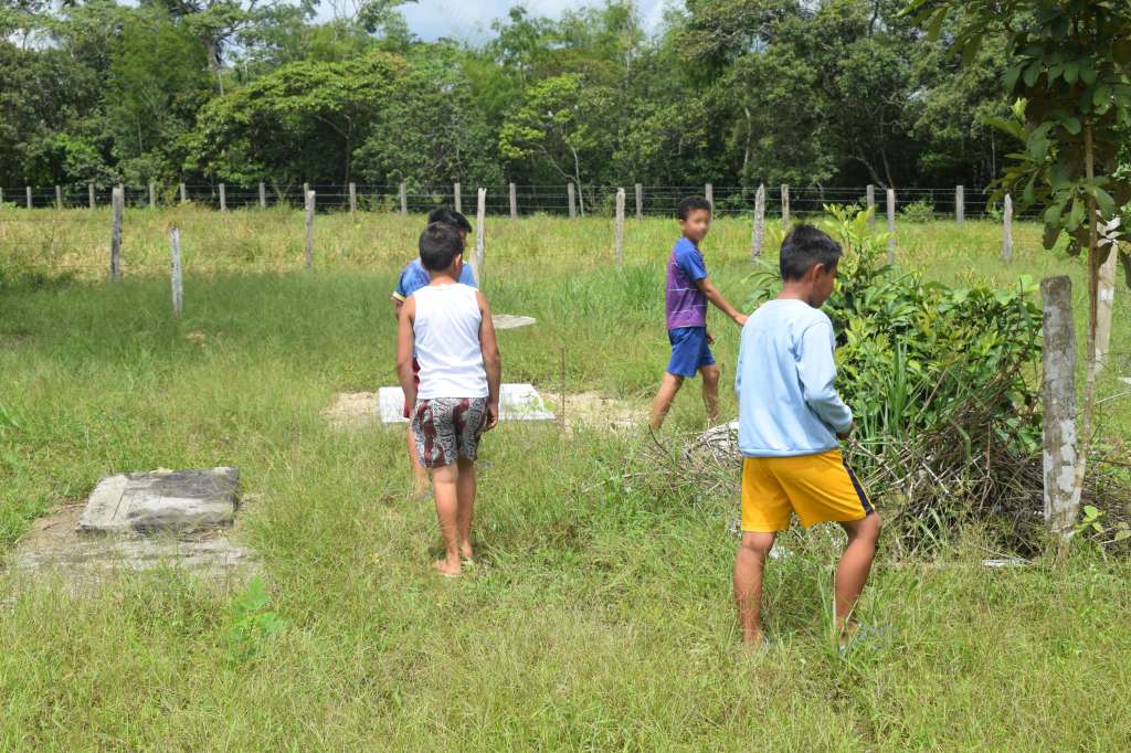Sorteando sus pasos, los cuatros niños recorren el cementerio de Nueva Colombia, buscando nombres y contando historias sobre los que ya no están.