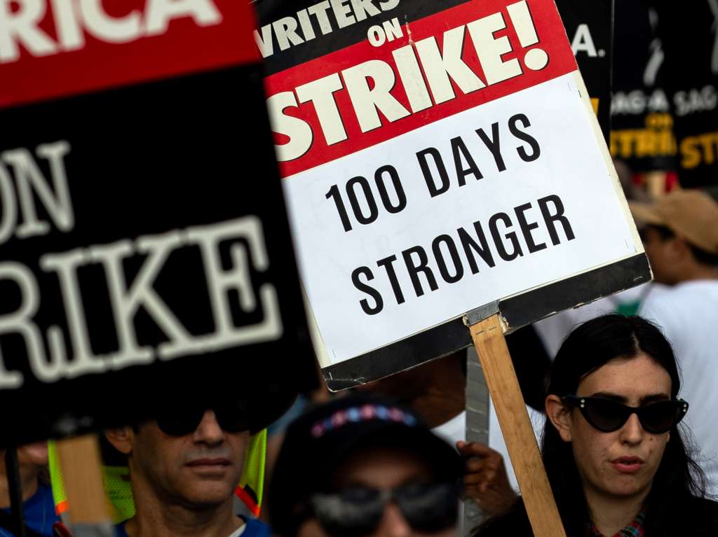 Los Angeles (United States), 09/08/2023.- A demonstrator holds a poster reading '100 days Stronger' as members of the Writers Guild of America (WGA) protest in front of the Netflix headquarter in Los Angeles, California, USA, 09 August 2023. Today marks the hundredth day of strike since the WGA announced they would start picketing on May 2nd over contract renegotiations. (Protestas) EFE/EPA/ETIENNE LAURENT