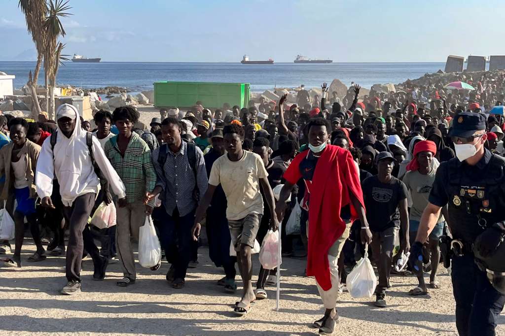 CEUTA, 20/08/2026.- Migrantes son desalojados de la playa del Trampolín en Ceuta tras habilitarse un espacio para su acogida este jueves. El Gobierno ha habilitado temporalmente varios espacios para la acogida de 1.800 personas migrantes que se encuentran en situación de calle en la playa del Trampolín y en la zona de Loma Colmenar, en Ceuta, que prevé ampliar progresivamente. EFE/Reduan
